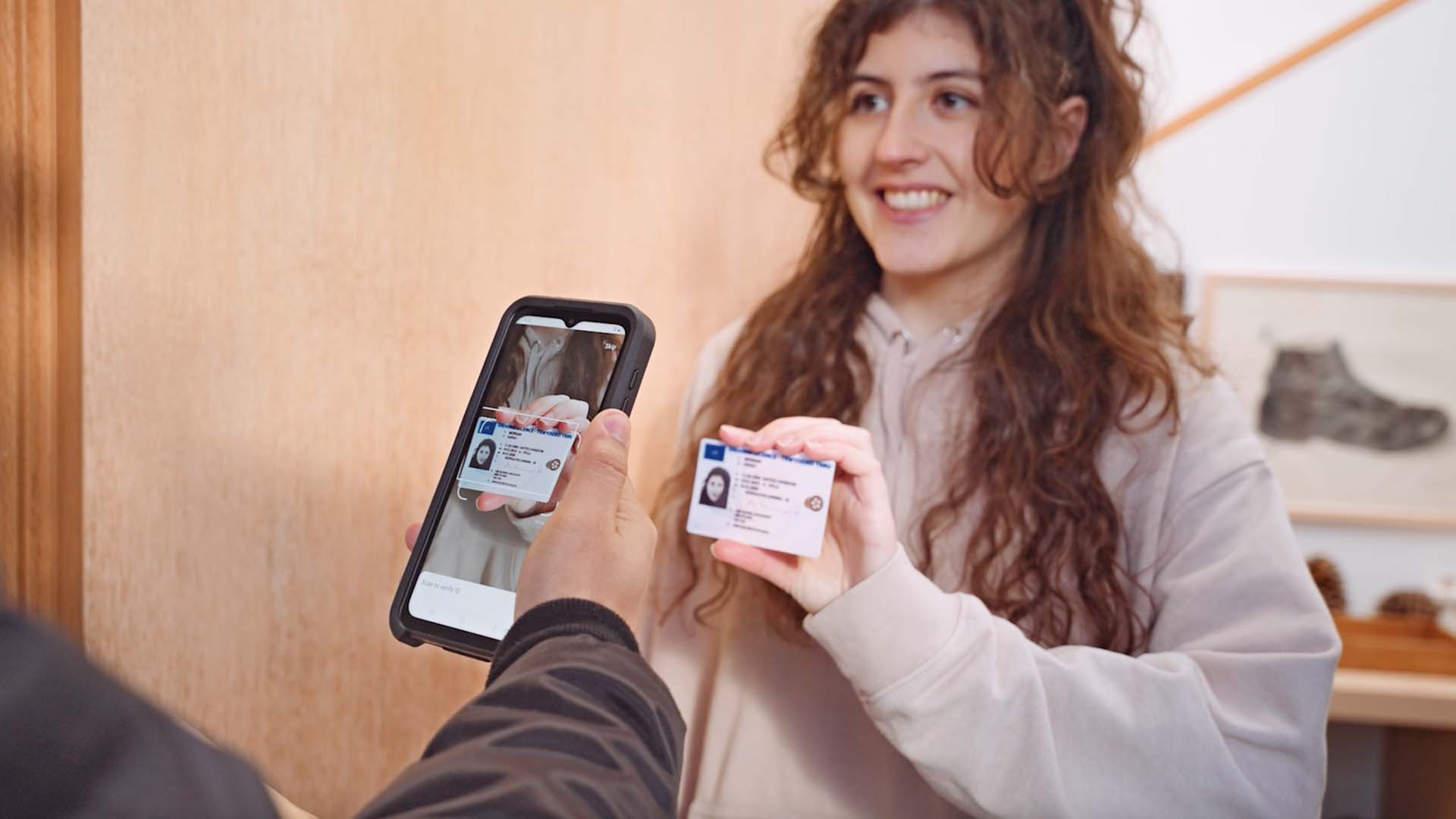 Delivery driver verifying the ID of the recipient using ID verification scanning on smartphone